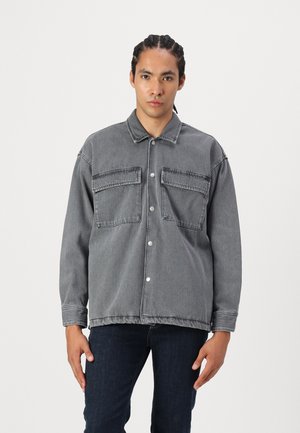 Grijze denimjas met een kraag, twee voorzakken, drukknoopsluitingen en een relaxte pasvorm met een licht gathered zoom.