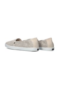 Beige instapk schoenen met geperforeerde bovenkant, suede accenten, witte rubberen zool en een logo op de hiel. Gladde textuur en ronde vorm.