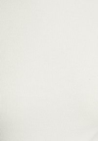 Tessuto bianco a coste con una trama liscia. Il materiale presenta linee verticali sottili e un motivo uniforme su tutta la superficie.