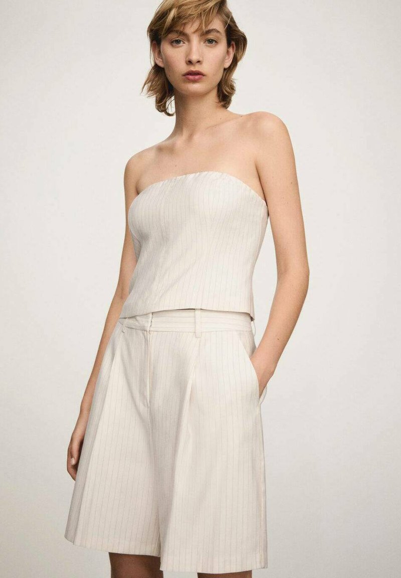 Strapless beige top with subtle vertical stripes paired with tailored beige shorts, featuring side pockets and a smooth texture.