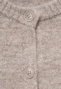 Sweter kardigan w beżowej wełnie z prążkowanym kołnierzem, z dwoma dużymi okrągłymi kremowymi guzikami i teksturowanym wzorem ściegów.