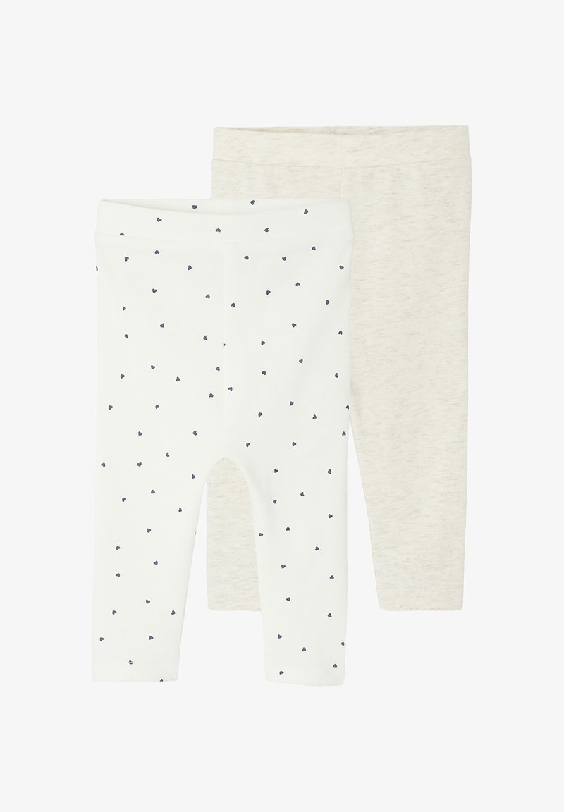 Zwei Paare Baby-Leggings; eines weiß mit kleinen schwarzen Herzmustern, das andere beige mit einem schlichten Design.