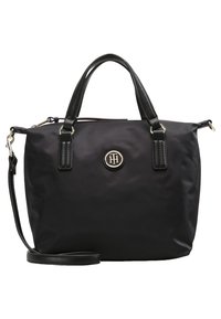 Sort håndtaske med to håndtag, en aftagelig skulderrem og et rundt metallogoemblem i midten foran.