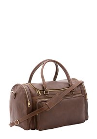 Bruine leren reistas met dubbele handvatten, verstelbare schouderriem, meerdere ritszakken en gouden hardware accenten.