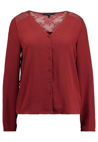 Blouse rouge à manches longues avec un col en V, détail en dentelle sur les épaules, et une fermeture boutonnée à l'avant. Confectionnée dans un tissu léger et lisse.
