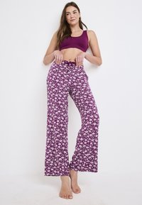 Paarse gestreepte wijde broek met een trekkoord in de taille, versierd met een bloemendessin in het wit. Zachte stof met een losse pasvorm.