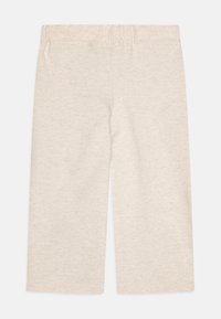 Ljusbeige bomullstights med elastisk midja, med en mjuk och lätt textur och raka ben. Inga mönster eller metallaccessoarer.