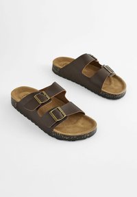 Braune Kunstleder-Sandalen mit zwei verstellbaren Schnallen, braunem Wildlederfußbett und gesprenkelter schwarzer Gummisohle. Offene Zehen-Design.