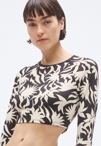 Μαύρο και κρεμ crop top με μακριά μανίκια, που διαθέτει υφασμένο λουλουδάτο σχέδιο, στρογγυλή λαιμόκοψη και εφαρμοστή σχεδίαση.