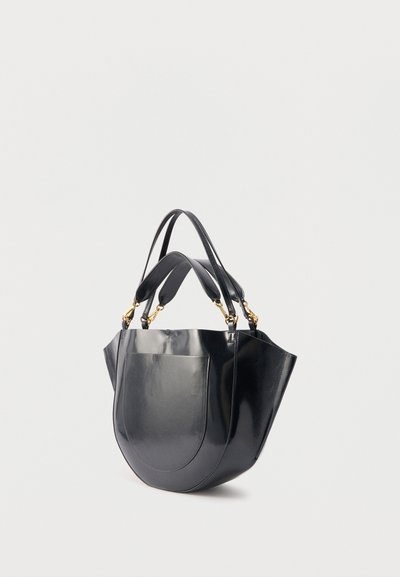 Μαύρη γυαλιστερή δερμάτινη τσάντα χειρός με μπροστινή τσέπη, δύο κοντές επενδεδυμένες λαβές και δύο λεπτές μακριές λουριά με χρυσές μεταλλικές λεπτομέρειες.