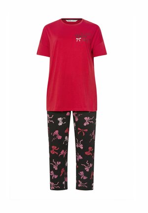 Rød bomulds T-shirt med teksten "IN MY ERA". Sorte bukser med blomstermotiv i pink og lyslilla, slim fit, ankellang design.