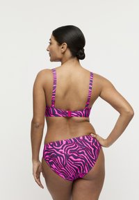 Roze en zwarte bikini met zebraprint, verstelbare bandjes en een sluiting met haakje. Heeft een gladde textuur en medium bedekking aan de onderkant.