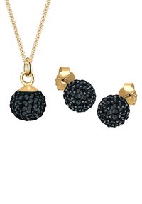 Schwarze Kristallkugel-Anhänger-Halskette an einer goldenen Kette, begleitet von passenden schwarzen Kristallkugel-Ohrringen. Detailreiche, strukturierte Oberflächen.
