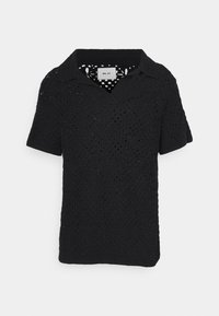 Polo negro de punto de manga corta con un patrón de crochet texturizado, cuello clásico y dobladillo recto. Etiqueta visible en el interior.
