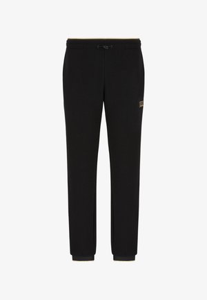 Schwarze Jogginghosen aus strukturiertem Stoff, mit einem elastischen Bund und Kordelzug sowie gerippten Bündchen. Goldenes Logo-Detail an der Seite.
