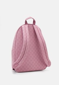 Ροζ σακίδιο με υφή υλικού που παρουσιάζει διακριτικό μοτίβο. Καμπυλωτό σχήμα, ρυθμιζόμενοι ιμάντες και πάνω λαβή για μεταφορά.