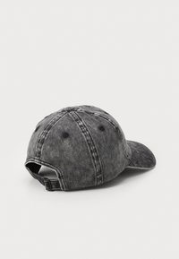 Denim pet in vervaagd zwart met een gebogen klep, zes-panel ontwerp, gestikte details en een verstelbare strap aan de achterkant.