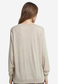 Hellbeiger Pullover mit langen Ärmeln, gerippten Bündchen und Saum. Weicher Stoff und einfaches Design, geeignet für legere Anlässe.