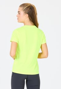 Lyhythihainen, tiukkaluonteinen t-paita kirkkaan neonkeltaisena, valmistettu kevyestä kankaasta. Sileä pinta, klassinen pyöreä kaulusdesign.