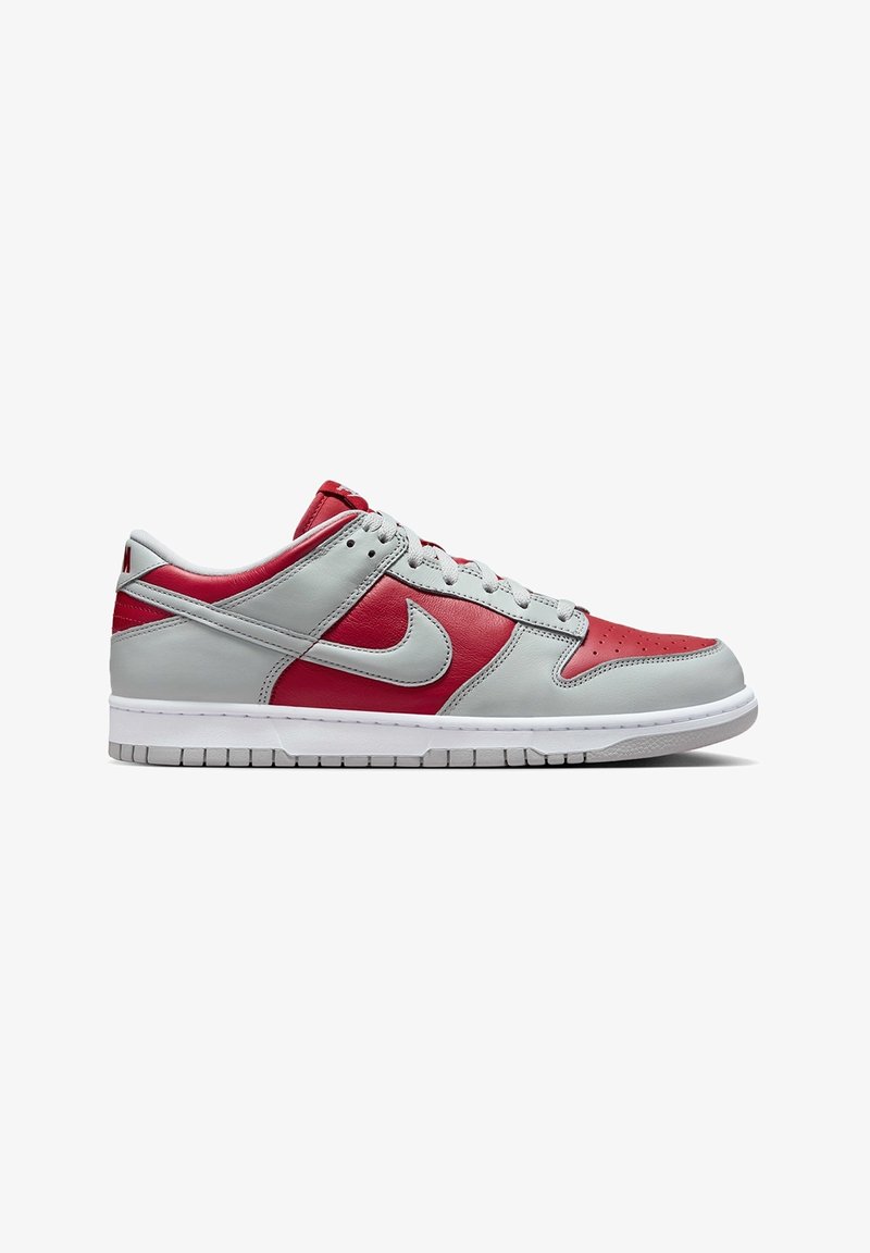 Nike Dunk Low sneakers med grå och röda läderpaneler, vit sula, perforerat tårbox och platta grå snörningar.