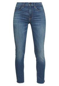 Jeans ajustados de mezclilla de peso medio, con un lavado azul, ligero desvanecimiento, dobladillos deshilachados, dos bolsillos frontales y cierre de botón.