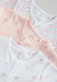 Tre body per neonati piegati in rosa pastello, bianco con stampe di fate e bianco con stampe floreali rosa, disposti sovrapposti.