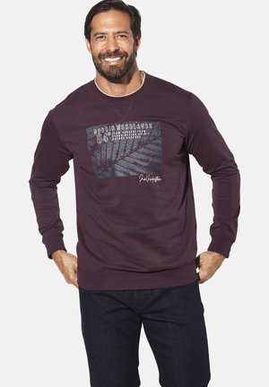 Dunkelrotes Sweatshirt mit langen Ärmeln, Grafikdruck mit Pflanzenmotiven und Text, Rundhalsausschnitt, gerippte Bündchen und Saum. Darunter dunkelblaue Jeans.