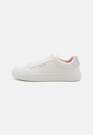 White slip-on sneaker with a smooth leather upper, rounded toe, and beige lining. Silver accent at heel, flat rubber sole, minimal stitching details.
