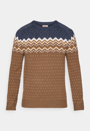 Ronde hals trui met een blauw, wit en bruin zigzag- en stippenpatroon, lange mouwen en geribbelde manchetten en zoom.