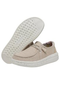 Scarpe slip-on in rete beige con una finitura testurizzata, lacci elastici e suola in gomma bianca maculata con un motivo ondulato. Interno foderato con un design floreale.