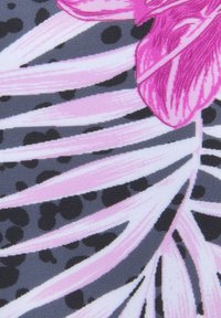 Floral stof in tinten van roze en grijs toont grote orchideeënbloemblaadjes en gedurfde, gebogen bladeren tegen een donkere achtergrond met stippen.