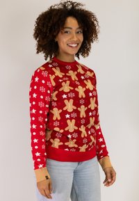 Red sweater featuring gingerbread man and snowflake patterns, with ribbed cuffs in beige. Material appears soft with a cozy fit.