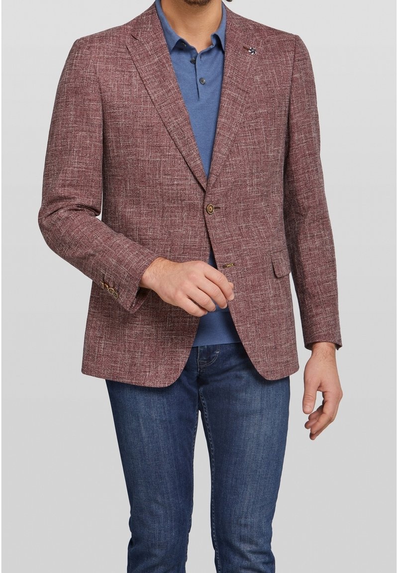 Blazer texturizzato bordeaux con chiusura a due bottoni, taschino sul petto e rever a notched, indossato sopra un polo blu e abbinato a jeans scuri.