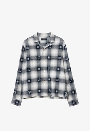 Košile na knoflíky s námořnickým a bílým kostkovaným vzorem, zdobená výšivkou mírového znamení a slunce. Vyrobena z měkké tkaniny, s volným střihem.