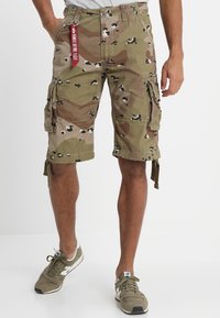 Pantalones cortos cargo con un patrón de camuflaje, que incluyen múltiples bolsillos, lazos ajustables en los dobladillos y una etiqueta de tela. Los colores incluyen verde, marrón y negro.