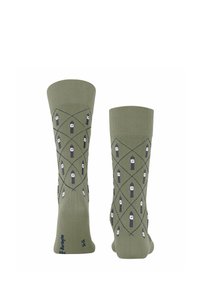 Grüne Baumwollsocken mit einem Rautenmuster, das abwechselnd Illustrationen eines Kerzenhalters in dunkelgrau und weißen Akzenten zeigt.