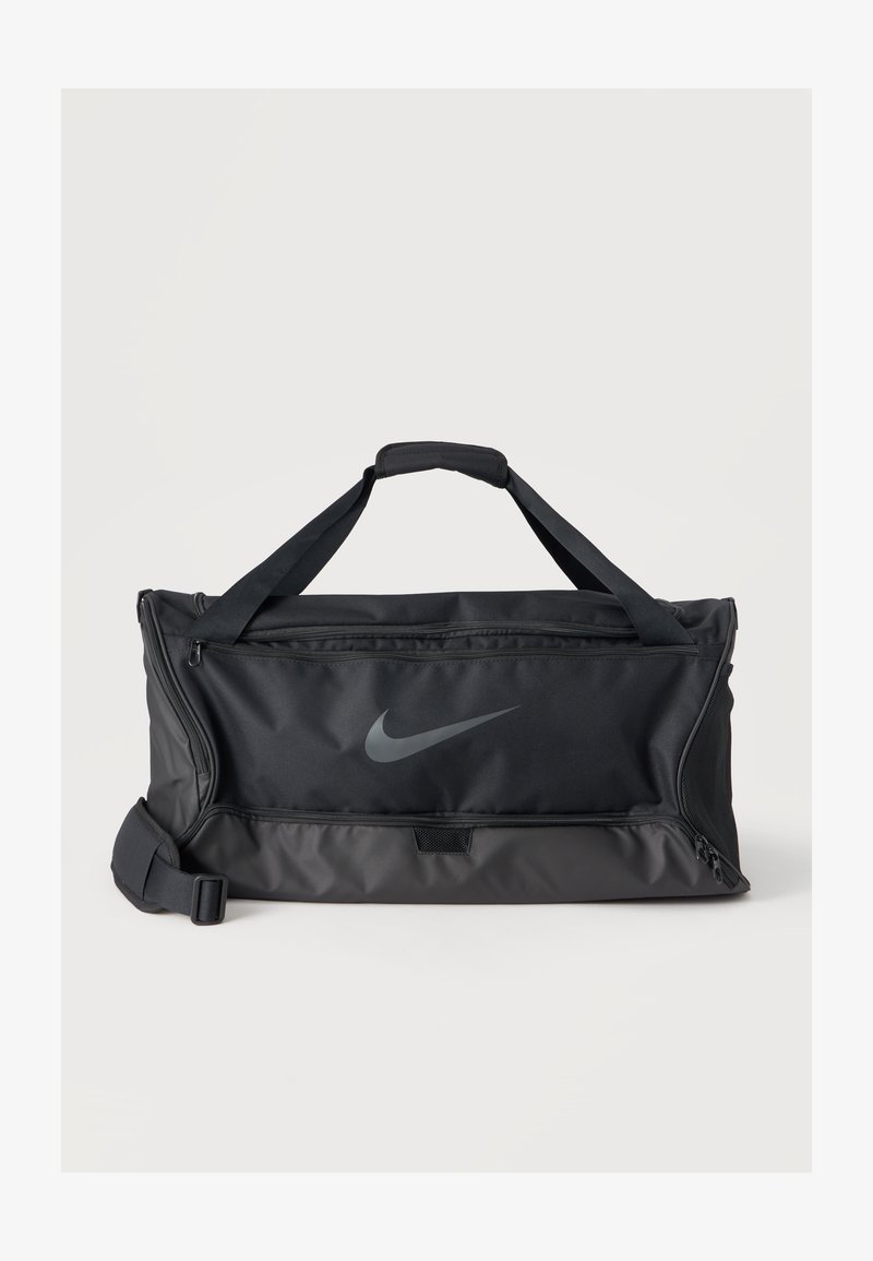 Μαύρη τσάντα Nike duffel με διπλές λαβές, ρυθμιζόμενο ιμάντα ώμου, μπροστινή τσέπη με φερμουάρ και λογότυπο swoosh πάνω σε μονόχρωμο φόντο.