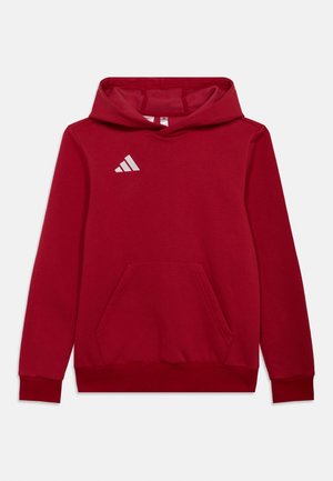 Felpa con cappuccio rossa in cotone, con tasca a marsupio frontale e logo Adidas bianco sul petto a sinistra.