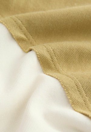 Material din bumbac cu un design divizat, având secțiuni texturate în khaki și secțiuni netede în alb, punând în evidență culorile contrastante și detaliile cusăturilor.