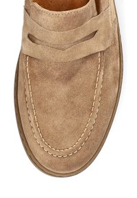 Beżowe zamszowe buty wsuwane z zaokrąglonym noskiem, dekoracyjnym przeszyciem i dwoma wycięciami na cholewce. Gładka tekstura i elastyczna podeszwa.