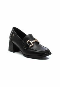 Mocassini neri in pelle con tacco grosso presentano un accento in metallo dorato e borchie metalliche sul tacco, con una texture liscia e un design a punta quadrata.