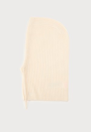 Cagoule en maille côtelée couleur crème, avec un haut arrondi et une ouverture pour le visage, présentée sur un fond uni.