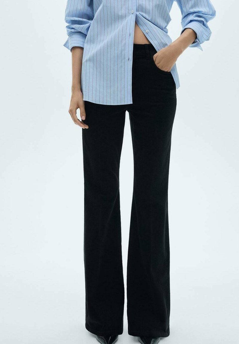 Zwarte flared broek van textuurstof, met een hoge taille en een slanke silhouet, gecombineerd met een blauw gestreept shirt.