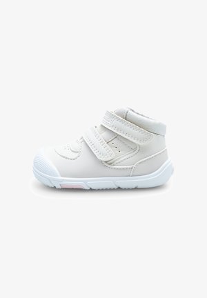 Baskets blanches pour tout-petits avec deux bandes Velcro réglables, col rembourré à la cheville et semelle texturée avec détail rose sur fond blanc.