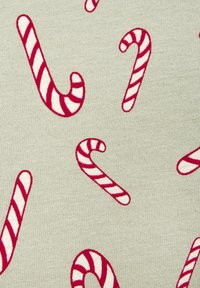 Weißer Stoff mit einem wiederholenden Muster aus rot-weiß gestreiften Zuckerstangen, die in verschiedenen Ausrichtungen angeordnet sind.