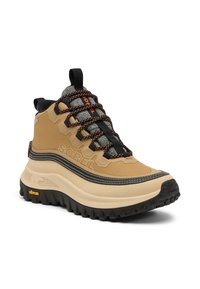 Botte de randonnée beige et noire avec une tige texturée, des lacets orange contrastants, un col rembourré et une semelle Vibram robuste pour une bonne adhérence.