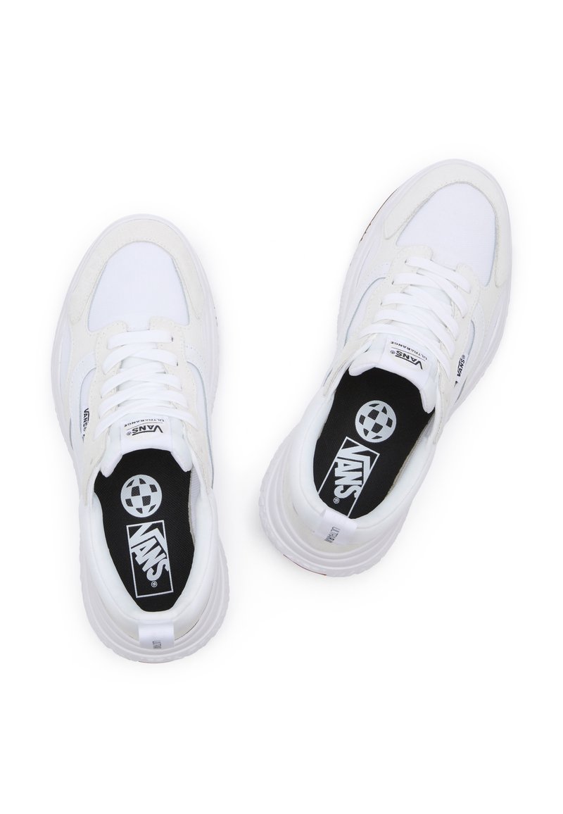 Zapatillas blancas que presentan una combinación de materiales lisos y texturizados, puntera redonda, cierre de cordones y plantillas negras en contraste con el logo.