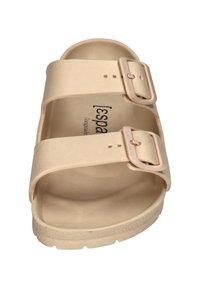 Beige two-strap sandal with adjustable buckles, smooth rubber material, and a contoured footbed. Minimal design and rounded edges.