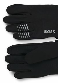 Black gloves featuring a smooth material, with a honeycomb texture on the palm and grey stripes. The brand name "BOSS" is visible on the wrist.