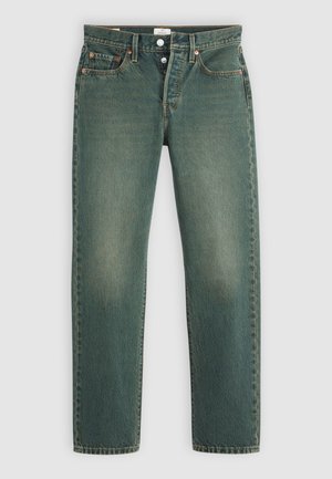 Vaqueros de mezclilla verde con un acabado ligeramente desgastado, cinco bolsillos, remaches de cobre y diseño de pierna recta. Cierre estándar con botón y cremallera.